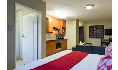 a room with a bed and a kitchen at Cozy Apartment in Hatfield in Pretoria