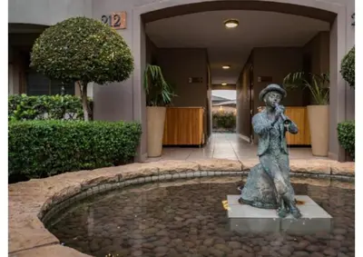 a statue of a woman sitting in front of a building at Cozy Apartment in Hatfield in Pretoria