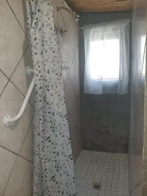 a shower curtain in a bathroom with a window at Chalet 4 at Cynthias Country in Hartbeespoort