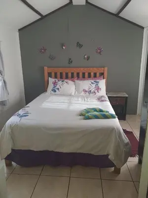 a bedroom with a large bed with pillows on it at Chalet 4 at Cynthias Country in Hartbeespoort