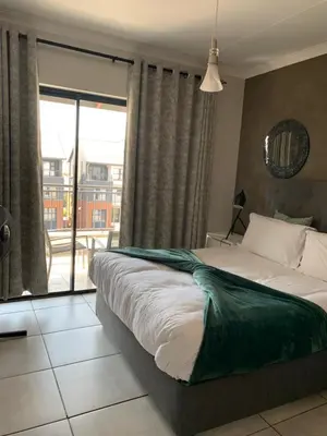 a bedroom with a bed and a large window at Sushii luxury apartment The Blyde in Pretoria