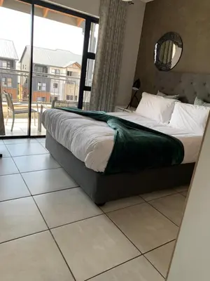 a bedroom with a bed and a large window at Sushii luxury apartment The Blyde in Pretoria