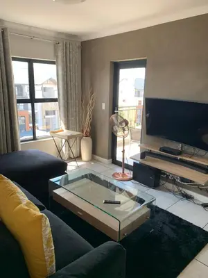 a living room with a couch and a glass coffee table at Sushii luxury apartment The Blyde in Pretoria