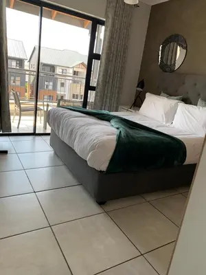 a bedroom with a bed and a large window at Sushii luxury apartment The Blyde in Pretoria
