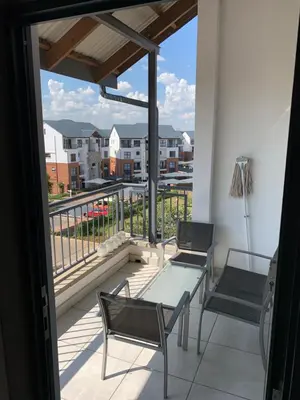a balcony with a table and chairs and a view at Sushii luxury apartment The Blyde in Pretoria