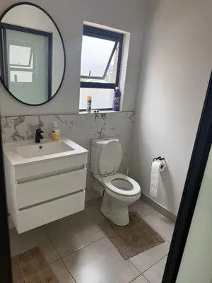 a bathroom with a toilet and a sink and a mirror at Treger views in Midrand