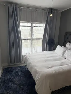 a bedroom with a large bed and a large window at Treger views in Midrand