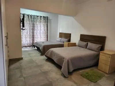 a bedroom with two beds and a window at Idube Power Hub Guest House in Benoni
