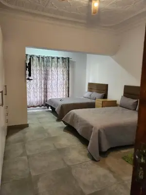 a bedroom with three beds and a window at Idube Power Hub Guest House in Benoni