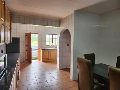 a kitchen with a table and chairs in a room at Idube Power Hub Guest House in Benoni