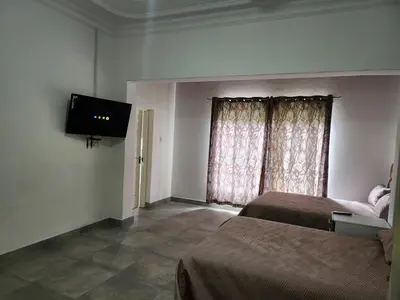 a bedroom with two beds and a flat screen tv at Idube Power Hub Guest House in Benoni