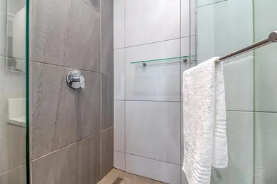 a bathroom with a shower with a glass door at Urban Luxury at The Trilogy in Pretoria