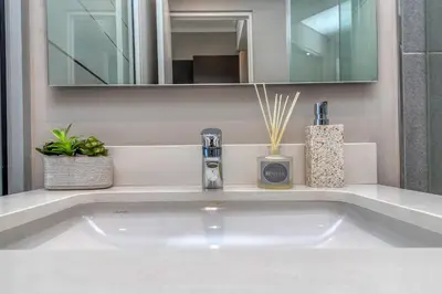 a bathroom with a white sink and a mirror at Urban Luxury at The Trilogy in Pretoria
