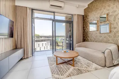a living room with a couch and a table at Urban Luxury at The Trilogy in Pretoria