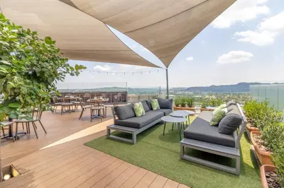 a patio with couches and tables on a roof at Urban Luxury at The Trilogy in Pretoria