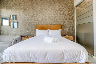a bedroom with a bed with a white bedspread at Urban Luxury at The Trilogy in Pretoria