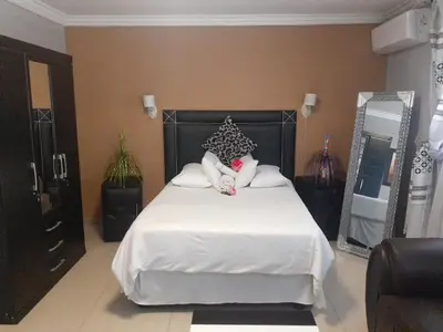 a bedroom with a large white bed with a doll on it at Leisure 45 Guest House in Kwaggafontein