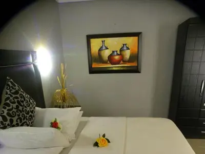 a bedroom with a bed and a painting of vases at Leisure 45 Guest House in Kwaggafontein