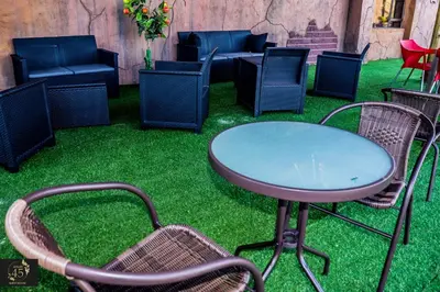 a table and chairs on grass with a patio at Leisure 45 Guest House in Kwaggafontein