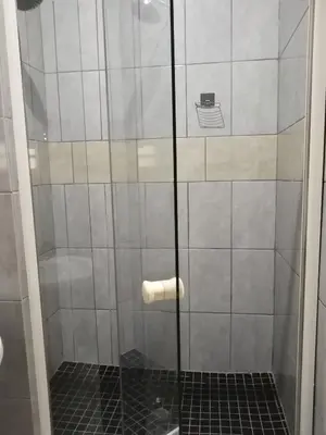 a shower with a glass door in a bathroom at Capital Park entire rental unit in Pretoria