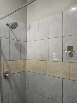 a bathroom with a shower with a glass door at Capital Park entire rental unit in Pretoria