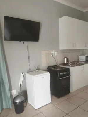 a kitchen with a black stove and a white refrigerator at Capital Park entire rental unit in Pretoria