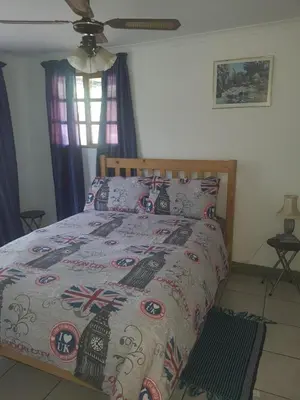 a bedroom with a bed with a pirate themed bedspread at Cottage 3 at Cynthias Country in Hartbeespoort