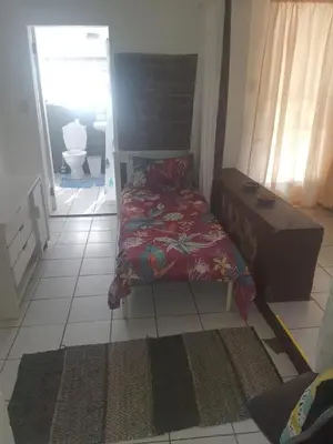 a small bedroom with a bed and a bathroom at Cottage 3 at Cynthias Country in Hartbeespoort