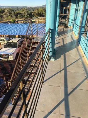 a balcony of a building with a car parked outside at samama guesthouse in Groblersdal