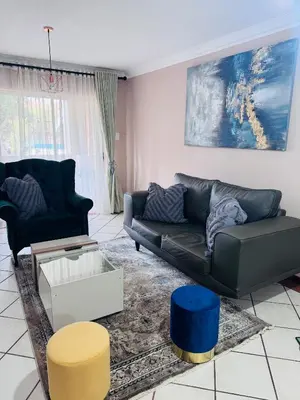 a living room with a couch and a table at Lovely Home away from Home in Centurion