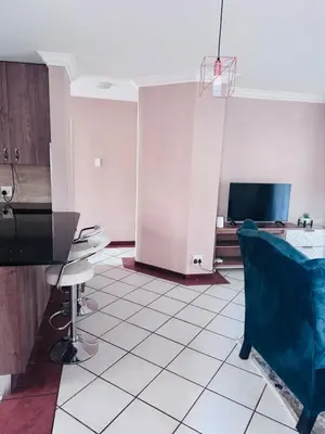 a living room with a table and chairs and a tv at Lovely Home away from Home in Centurion