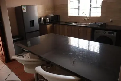 a kitchen with a black counter top and two toilets at Lovely Home away from Home in Centurion