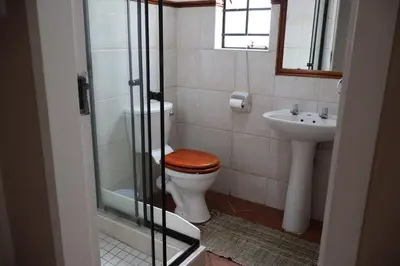 a bathroom with a toilet and a sink at Lovely Home away from Home in Centurion