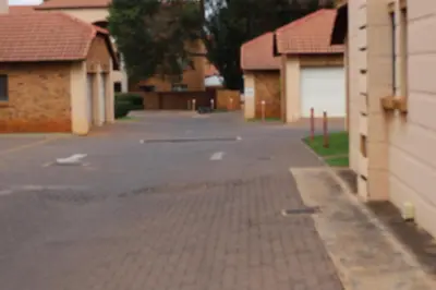 an empty street with houses and a brick sidewalk at Lovely Home away from Home in Centurion