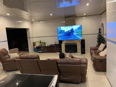 a living room with couches and a flat screen tv at Berry Home 4U in Pretoria