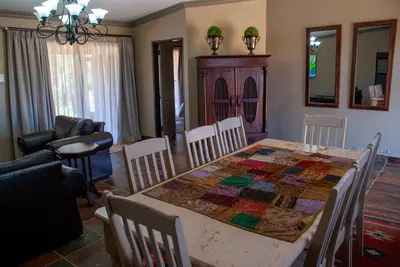 a dining room with a table with a quilt on it at Casa de la Presa 5 in Polokwane