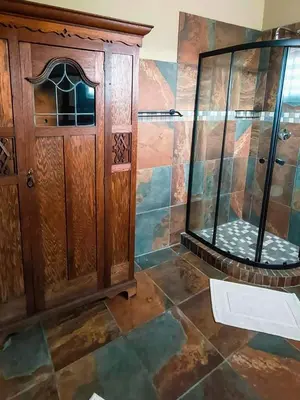 a bathroom with a shower and a wooden cabinet at Casa de la Presa 5 in Polokwane