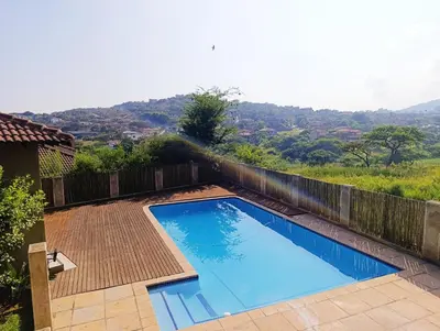 a large blue swimming pool with a wooden fence at Elephant Villa in Nelspruit