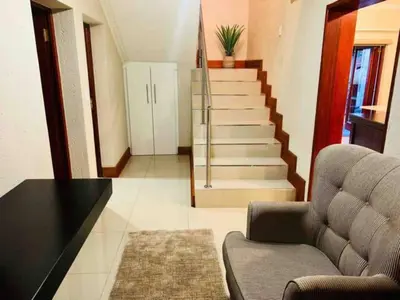 a living room with a couch and a staircase at Elephant Villa in Nelspruit