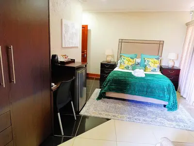a bedroom with a bed and a desk in it at Elephant Villa in Nelspruit