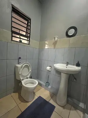 a bathroom with a toilet and a sink at Entire rental unit in Pretoria