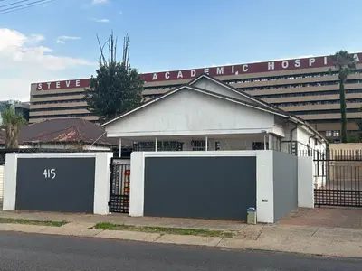 a building with two garage doors in front of a hospital at Entire rental unit in Pretoria