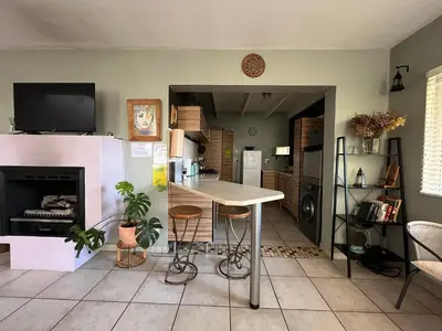 a living room with a table and a fireplace at Tranquility in the Trees Loft Style Apartment in Pretoria