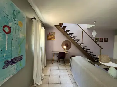 a living room with a staircase and a table at Tranquility in the Trees Loft Style Apartment in Pretoria