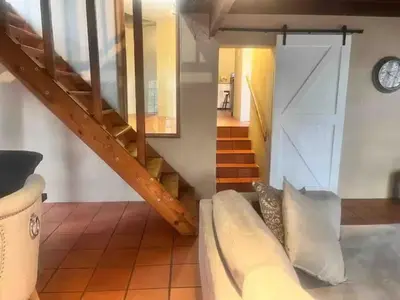 a staircase in a room with a couch and a clock at Executive loft at Brooklyn in Pretoria