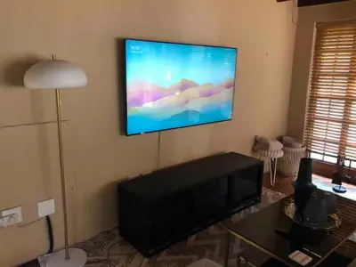 a living room with a flat screen tv on the wall at Executive loft at Brooklyn in Pretoria
