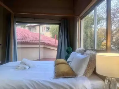 a bed in a room with a large window at Executive loft at Brooklyn in Pretoria