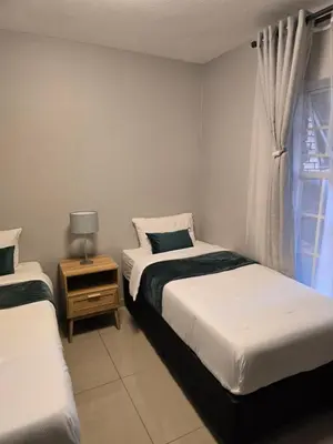 a bedroom with two beds and a window at Ikar's Haven in Centurion