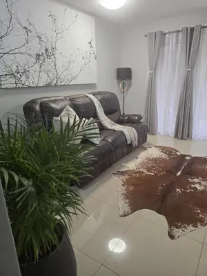 a living room with a leather couch and a plant at Ikar's Haven in Centurion