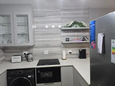a kitchen with a washer and dryer on a counter at Ikar's Haven in Centurion